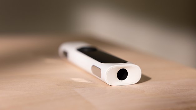 A white Withings BeamO device lying on a wooden surface.