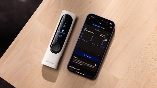 A Withings BeamO device next to a smartphone displaying ECG data.