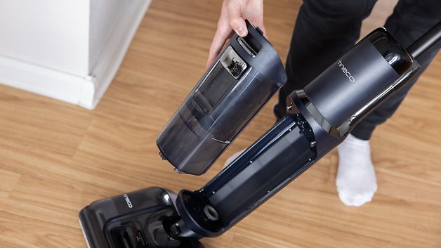 A person holds a floor of Tineco with one of a vacuum cleaner that extends with a removable dust container.