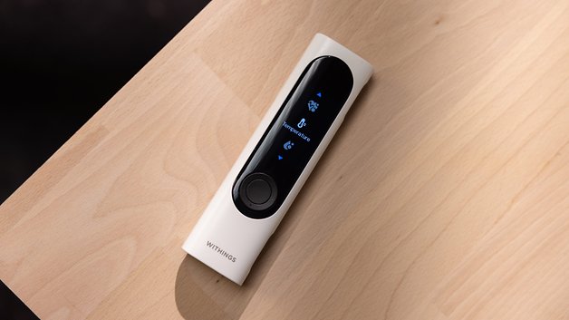 A Withings BeamO device on a wooden surface, displaying health metrics.