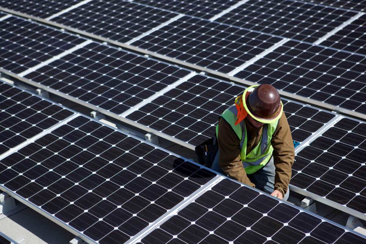 Meta 650 megawatts of solar energy adds to pushing artificial intelligence 1 A man inspects solar panels.