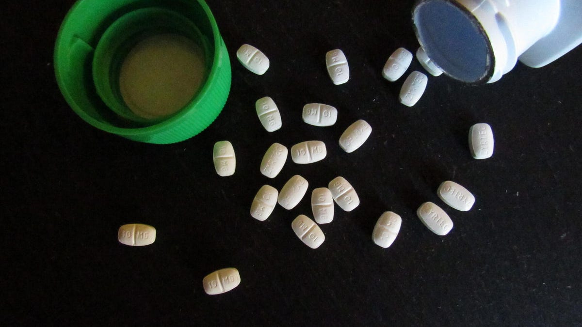 The Zyrtec and Xyzal mark are placed by FDA for a new side effect. How do you know when to see your doctor 1 Zyrtec tablets on a black surface next to open bottle and green cap.